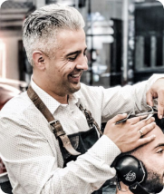 Arthur, the owner of Barber’s blueprint, giving a haircut to a customer in his barbershop.